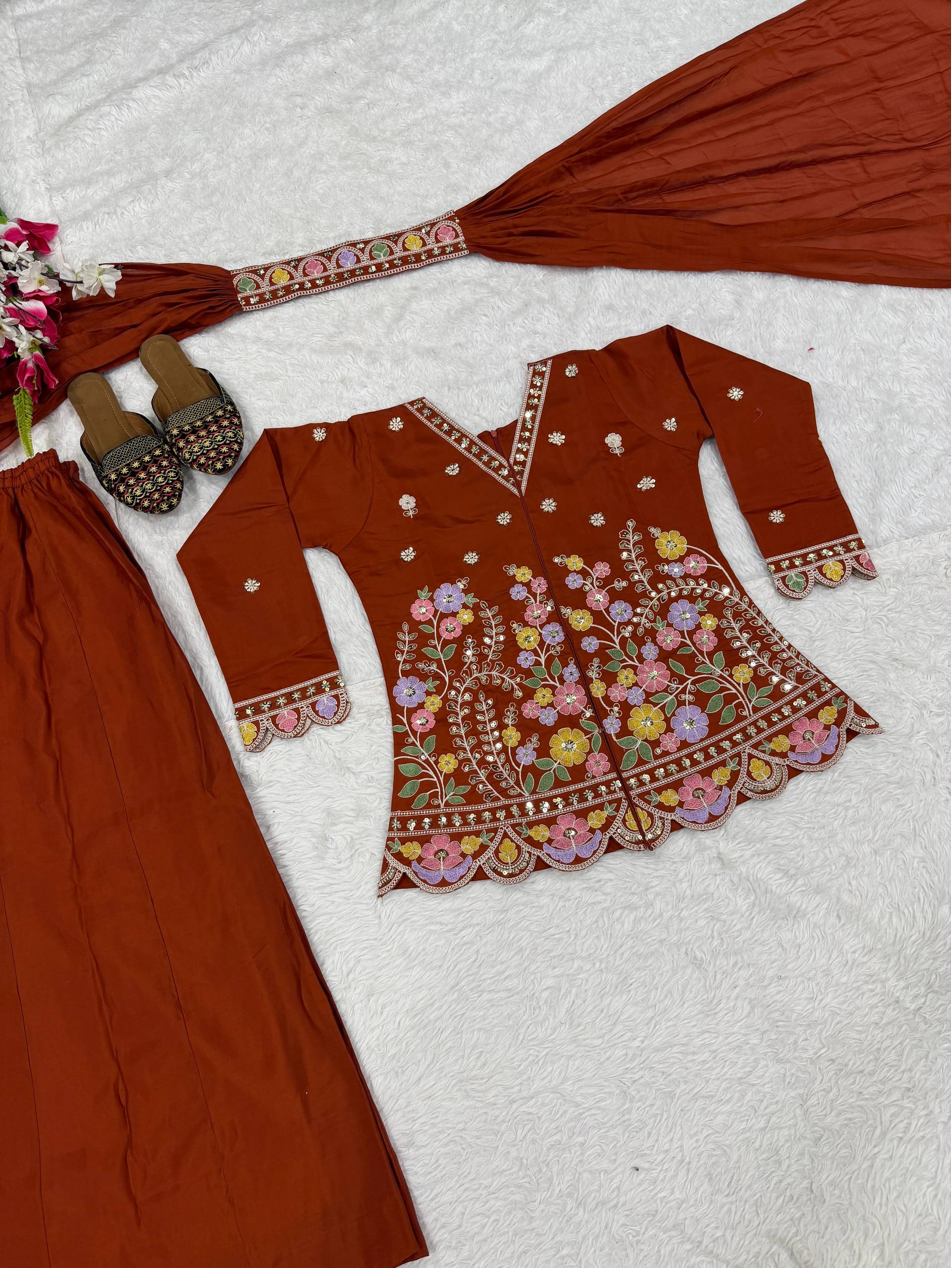 Resplendent Rust Orange Peplum Kurti and Flared Palazzo Suit Set Adorned with Intricate Multicolored Floral Embroidery, Sequin Accents, and Ornate Scalloped Borders